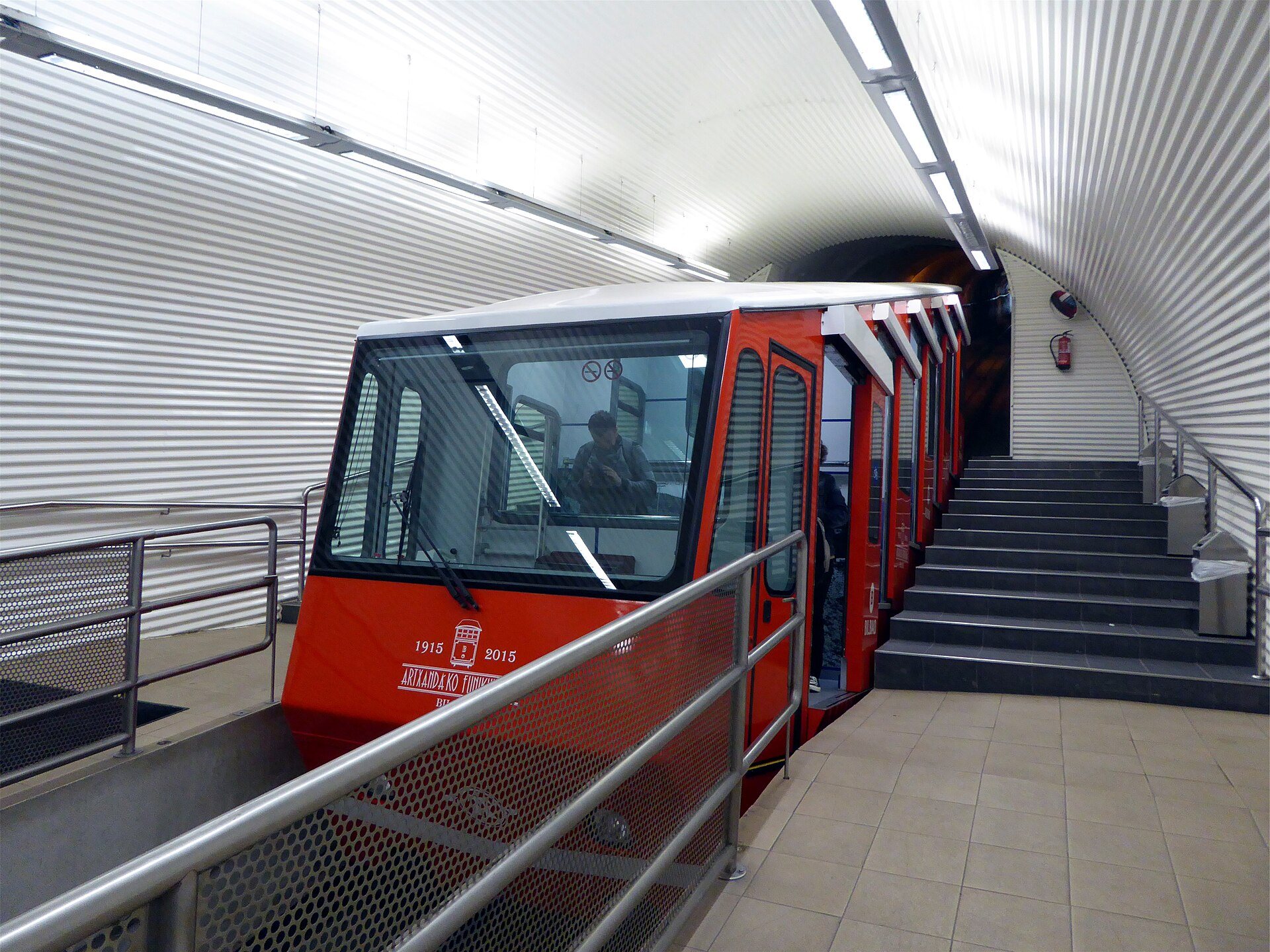 A red funicular car waiting at the platform of the lower Artxanda station
