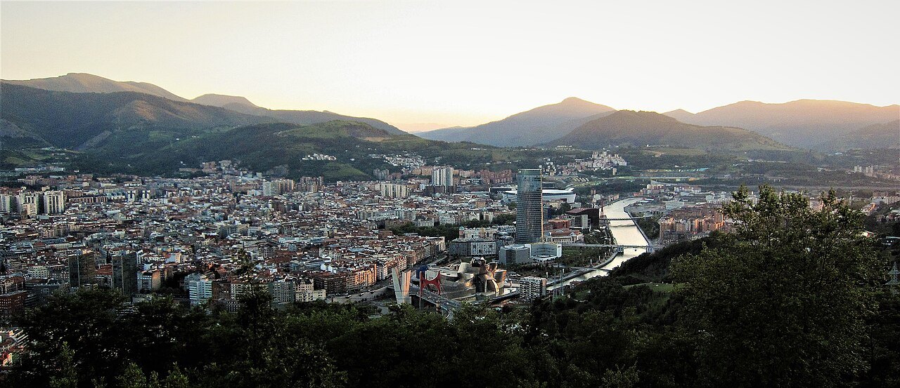 Bilbao at dusk from the hills, the river glinting through the city