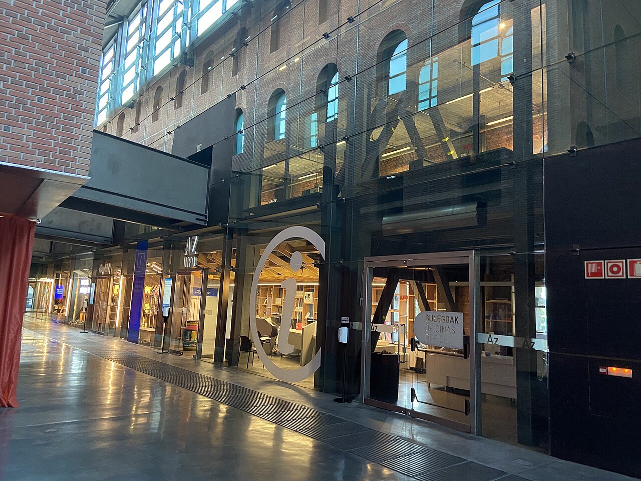 Inside Azkuna Zentroa, the glass and brick of the atrium at ground level
