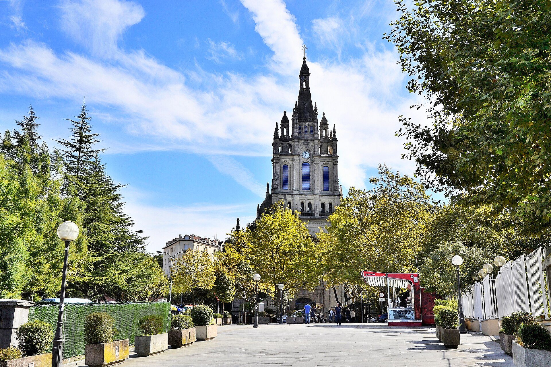 The Basilica of Begoña at the end of a tree-lined walk, its spire against blue sky
