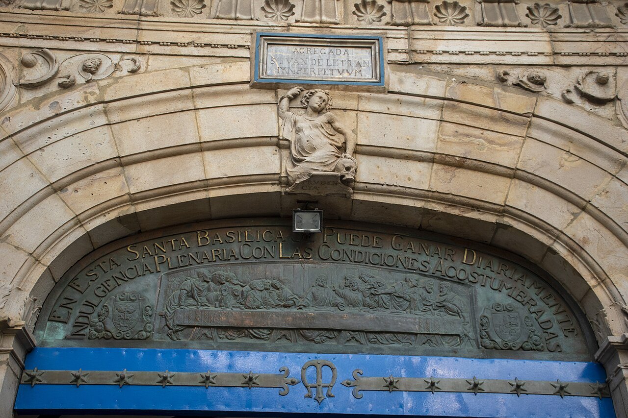 A carved stone lunette over a doorway at Begoña, framed by blue tiles