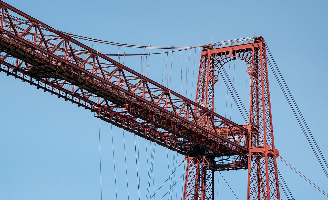 The red lattice girder of the Bizkaia Bridge meeting one of its towers