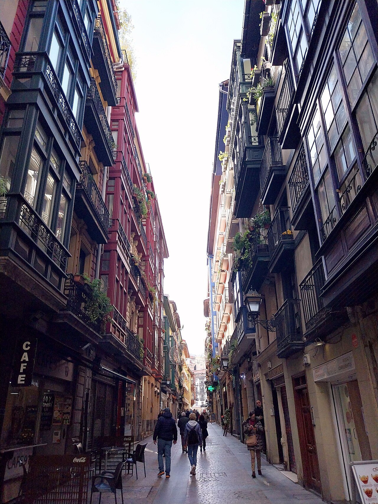 Calle Carnicería Vieja, narrow between tall houses with glazed balconies