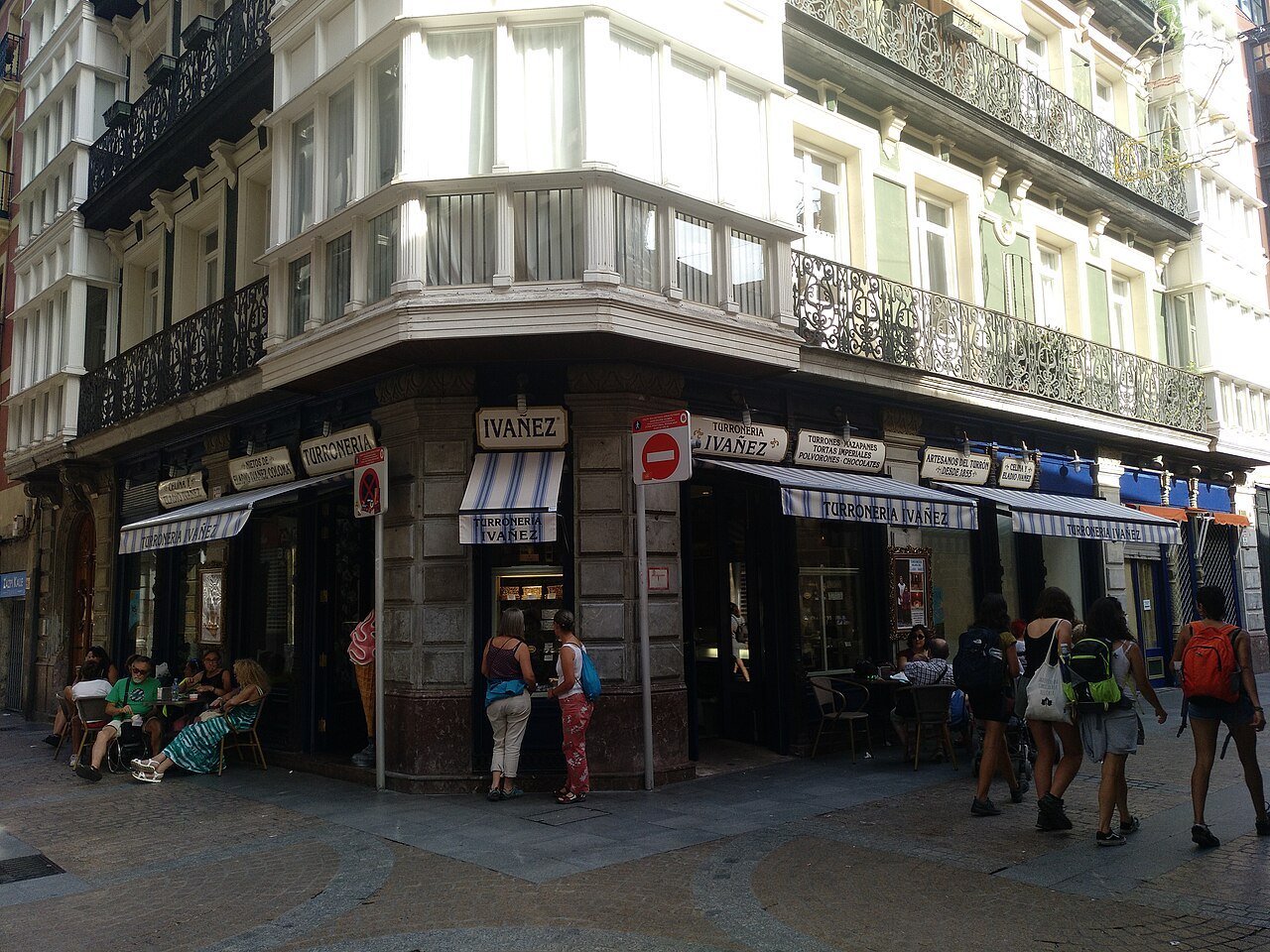 Bars and shops at a corner of the old town, glazed balconies above
