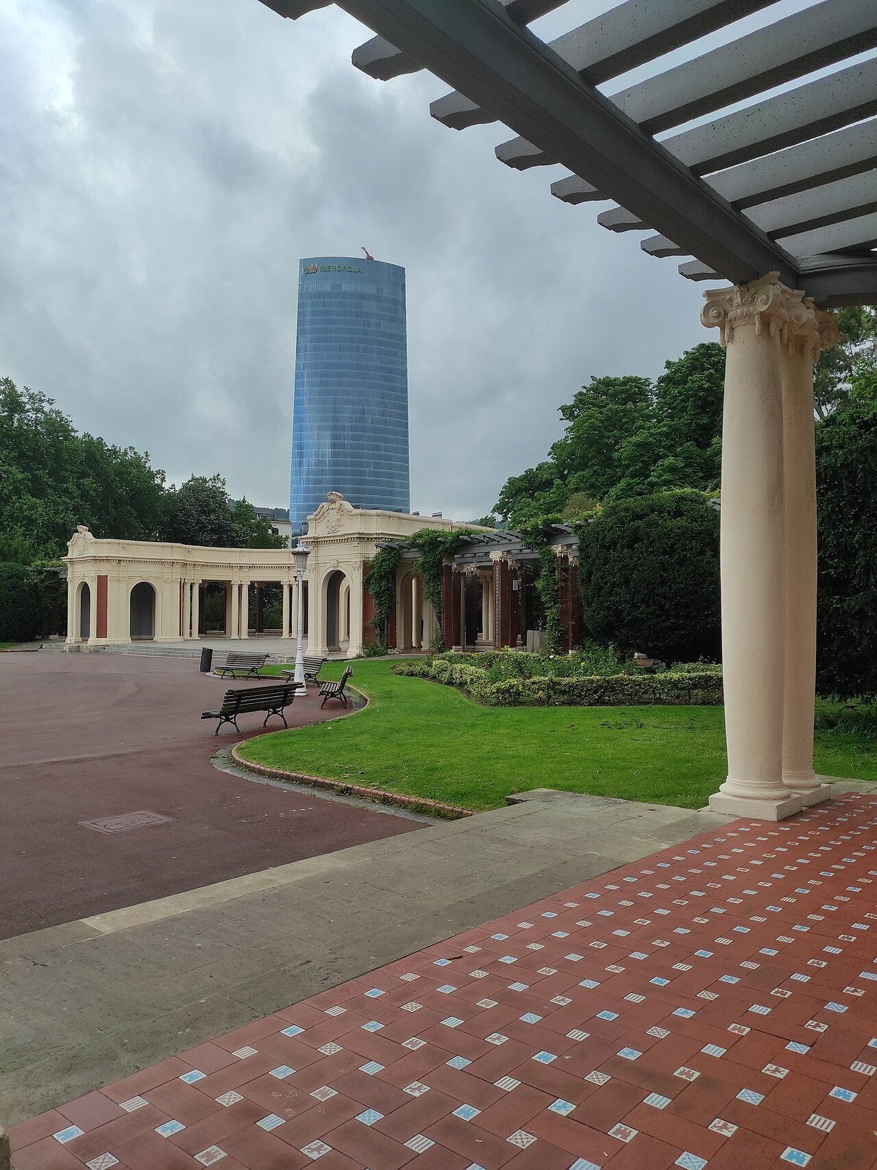 The colonnade of the pergola, the Iberdrola Tower beyond the trees