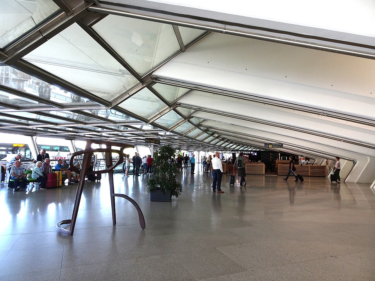 The airy arrivals hall under the white roof of Bilbao Airport
