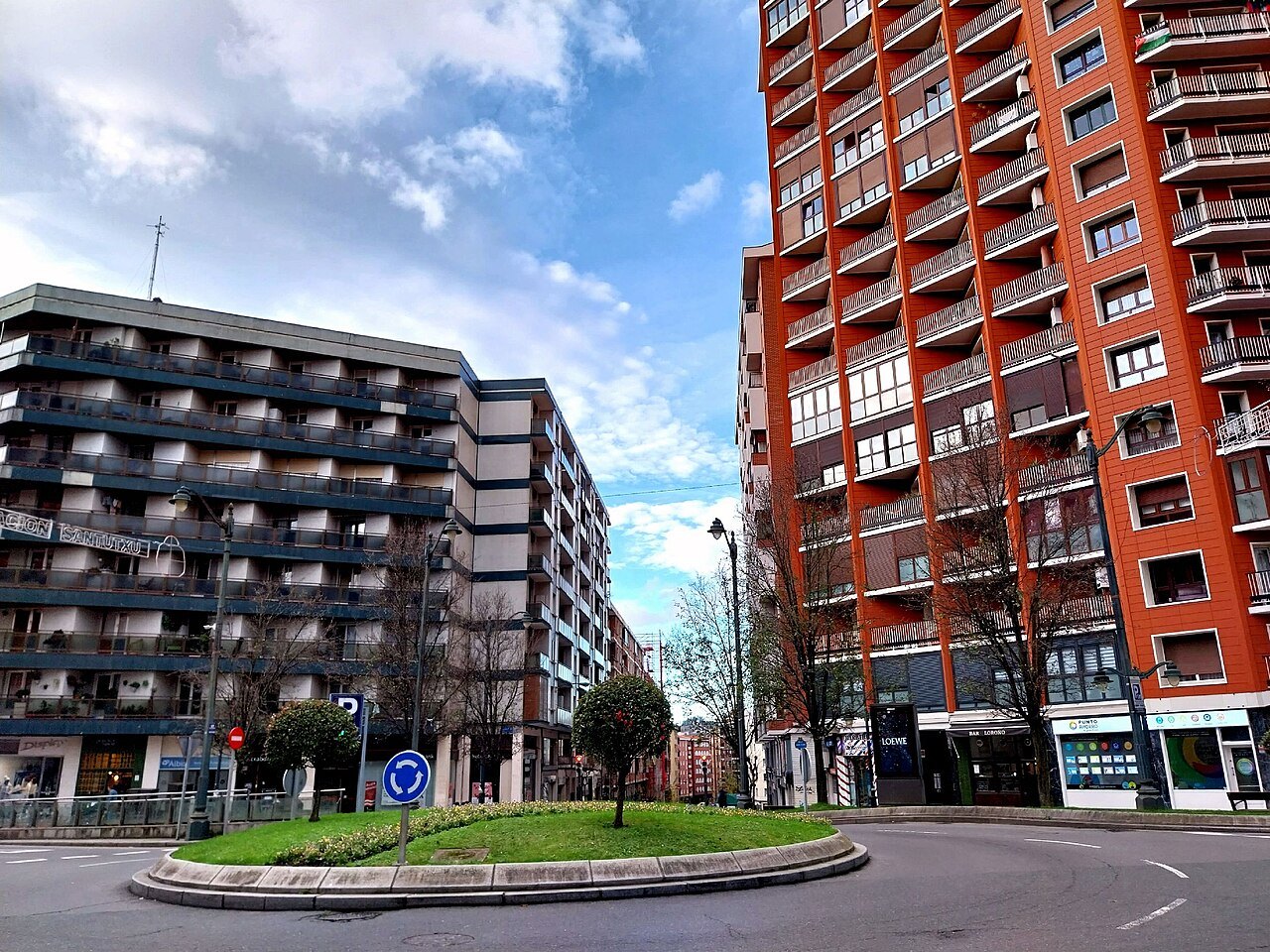 A roundabout among the red and dark apartment blocks of Santutxu