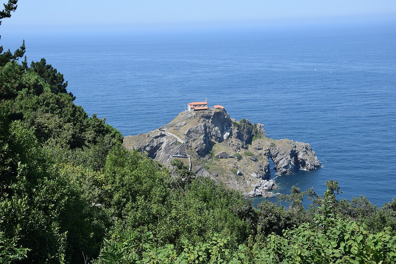 Gaztelugatxe seen from the wooded cliffs, the hermitage on top of the rock