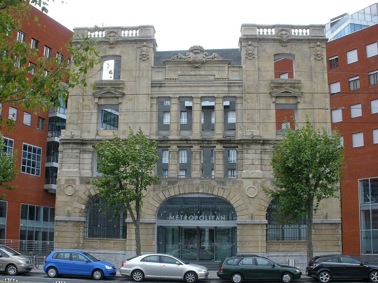 A restored stone warehouse front on the Paseo de Uribitarte, between modern blocks