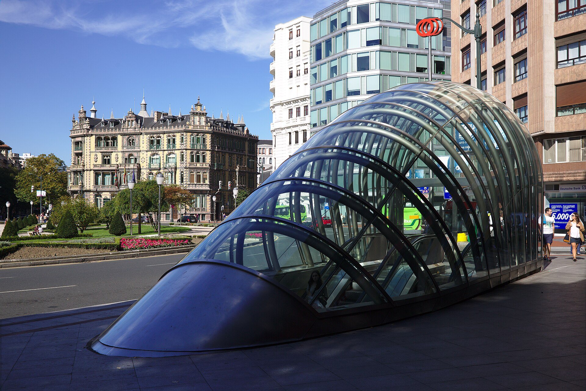 A glass fosterito arching over the entrance to Moyua Metro station