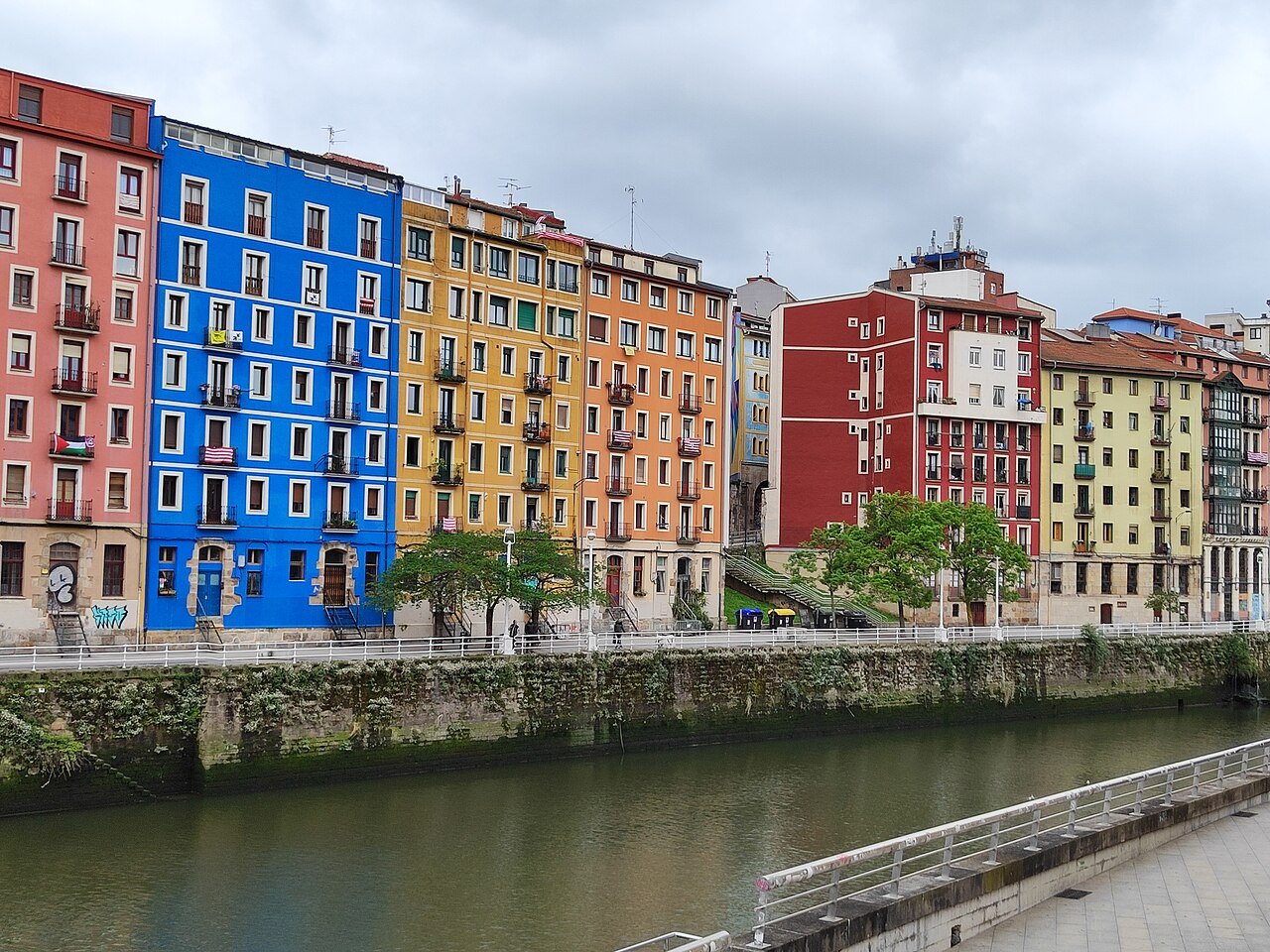 The painted houses of the Muelle de Marzana reflected across the river