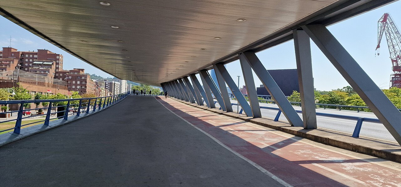 The covered walkway along the Euskalduna bridge, its steel struts angled over the pavement