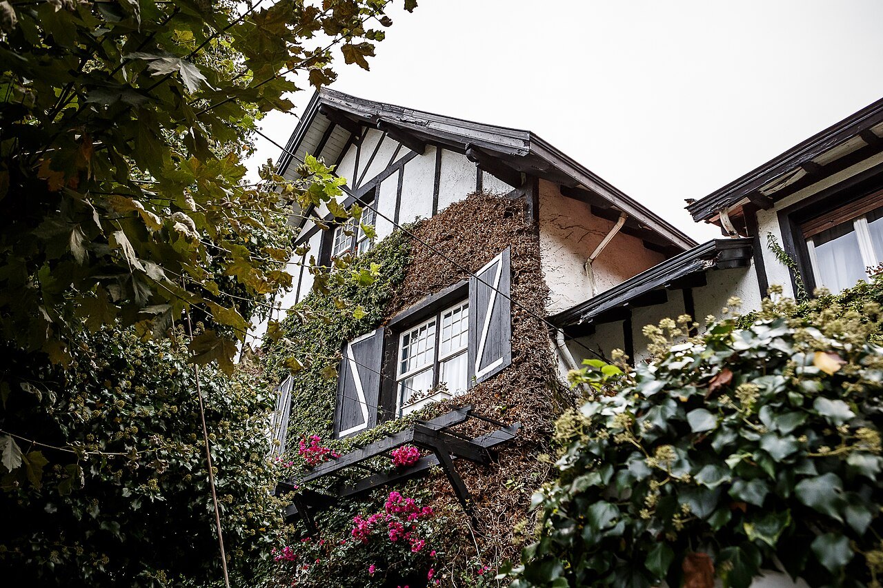 A half-timbered house half hidden by ivy and flowers in Getxo