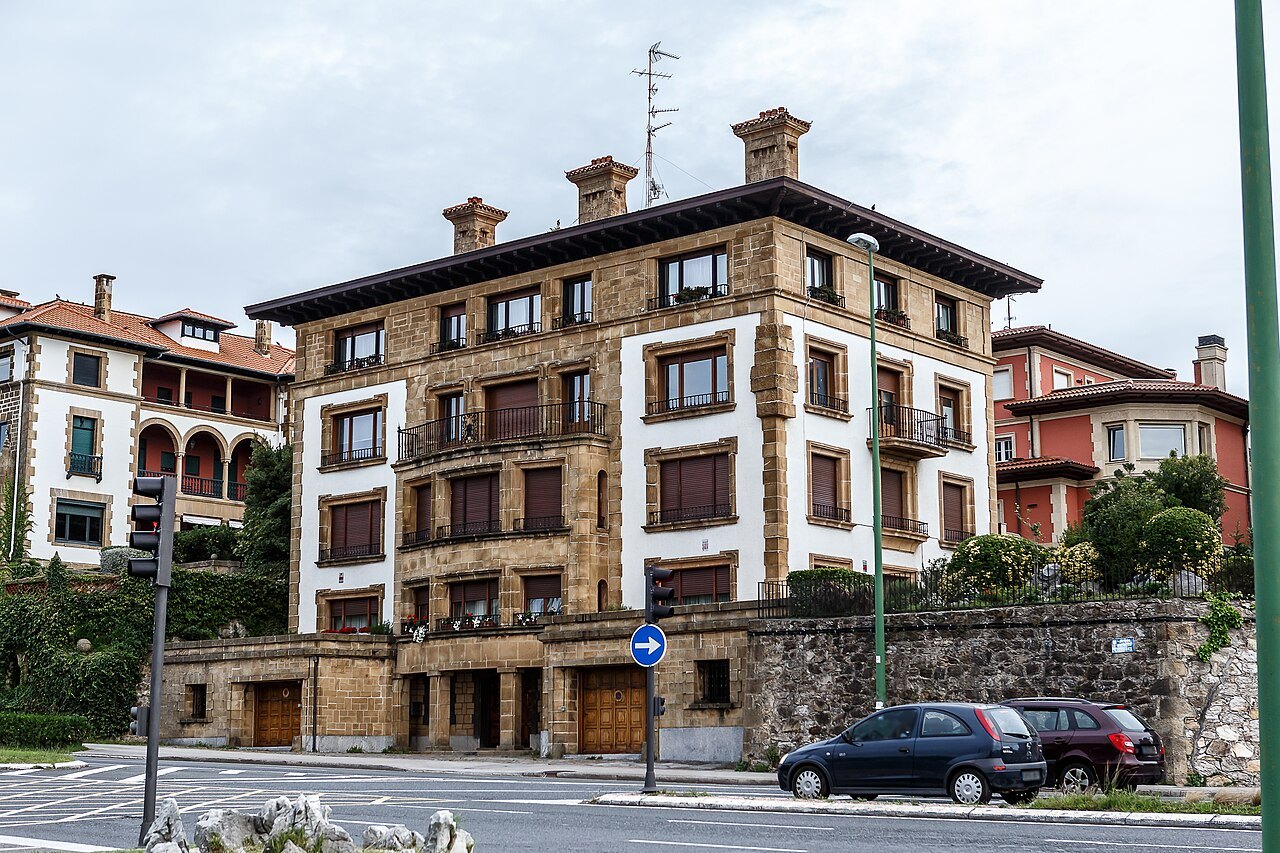 A stone-and-white apartment house with corner turrets in Getxo