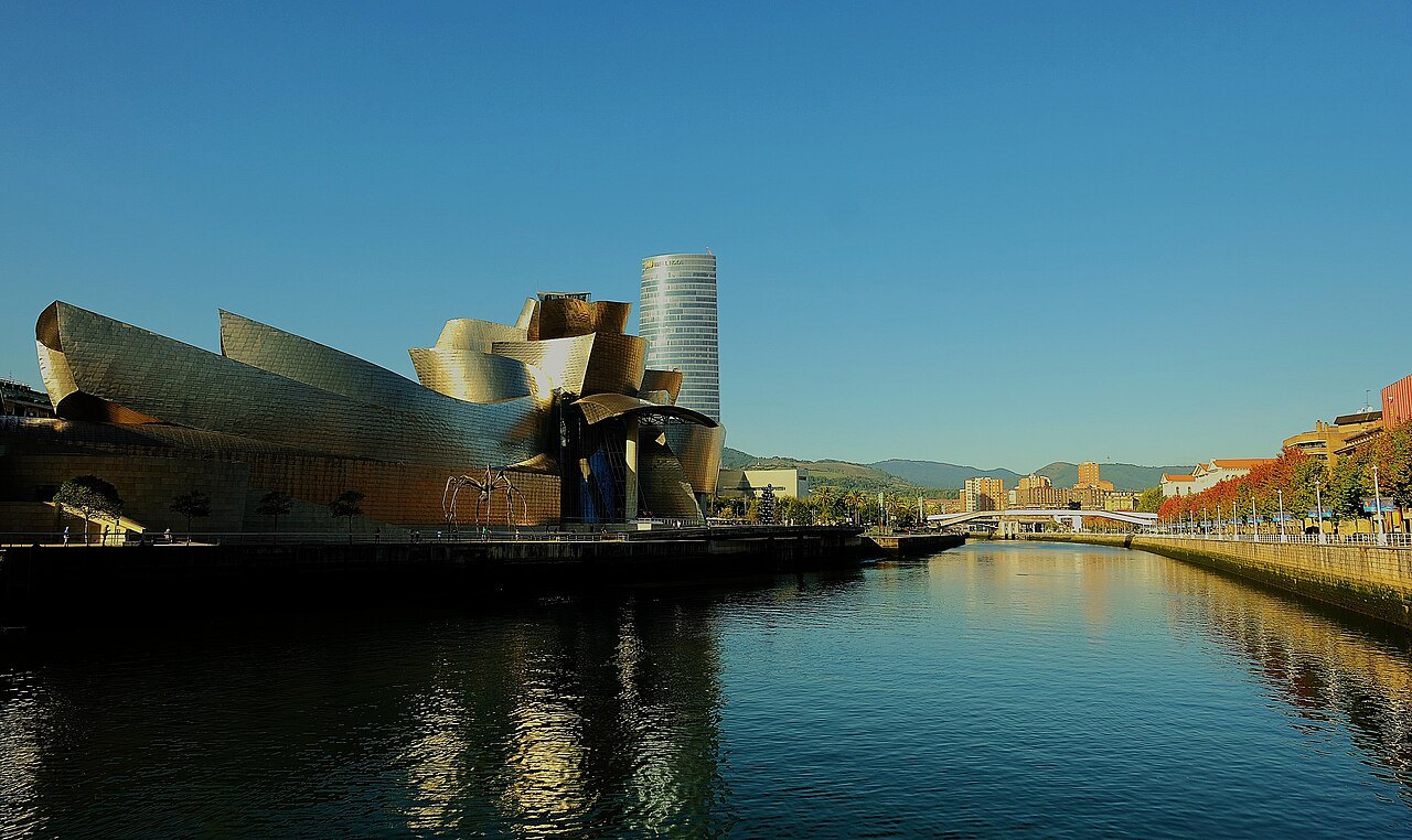 The Guggenheim and its tower reflected in the river in evening light