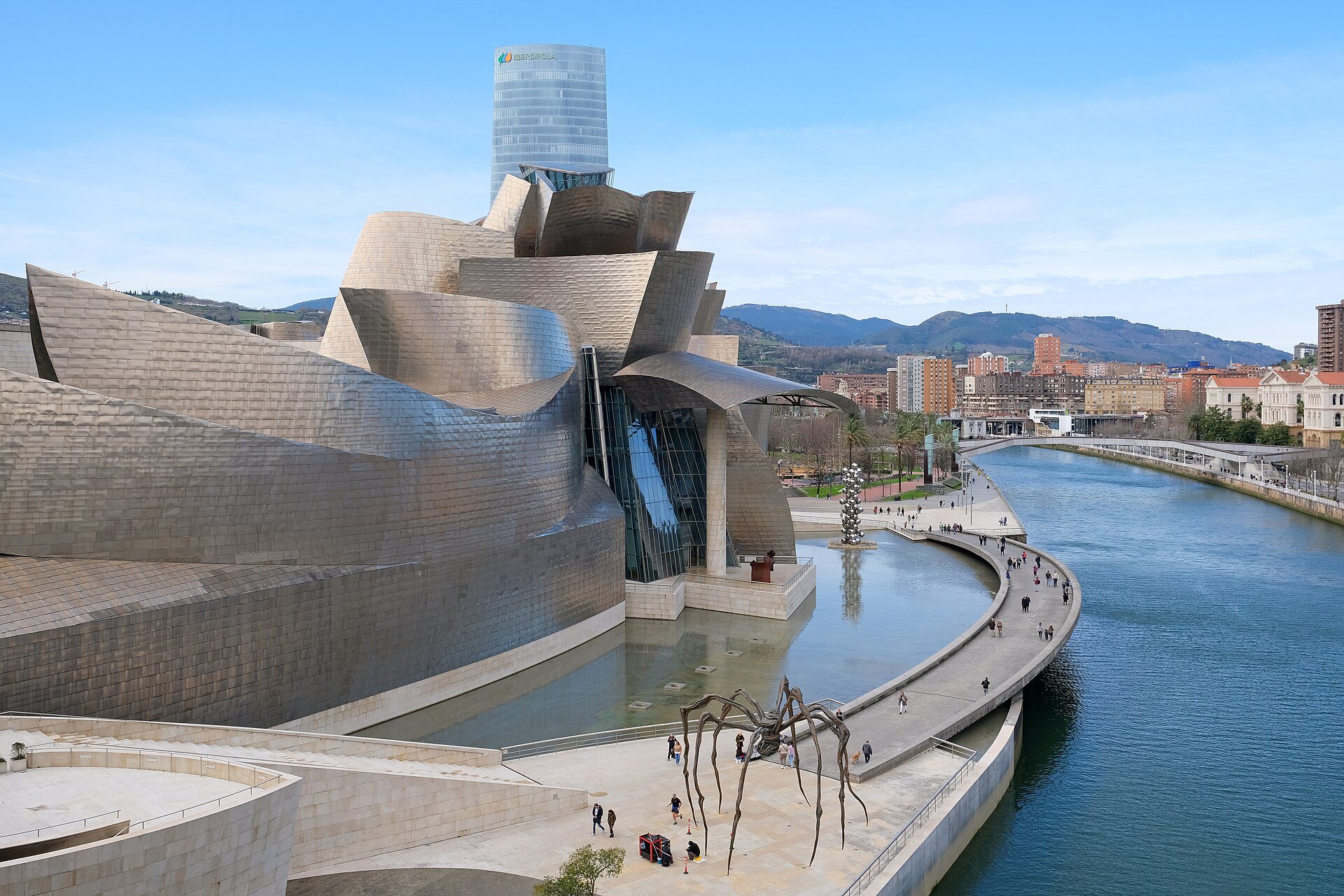The Guggenheim curving along the river, Maman on the quay and the Iberdrola Tower behind