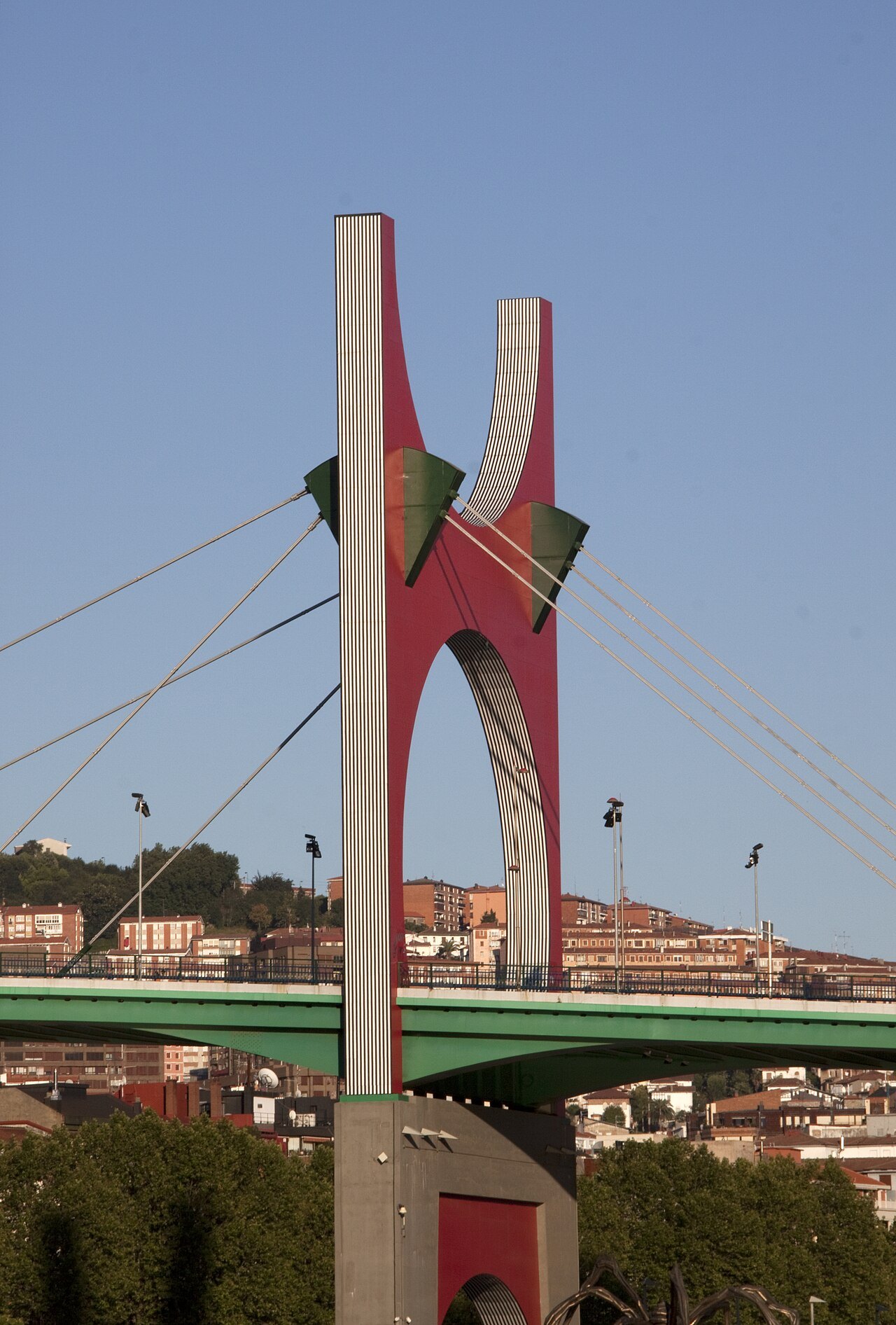 One red leg of Buren's arch rising beside the bridge's cables