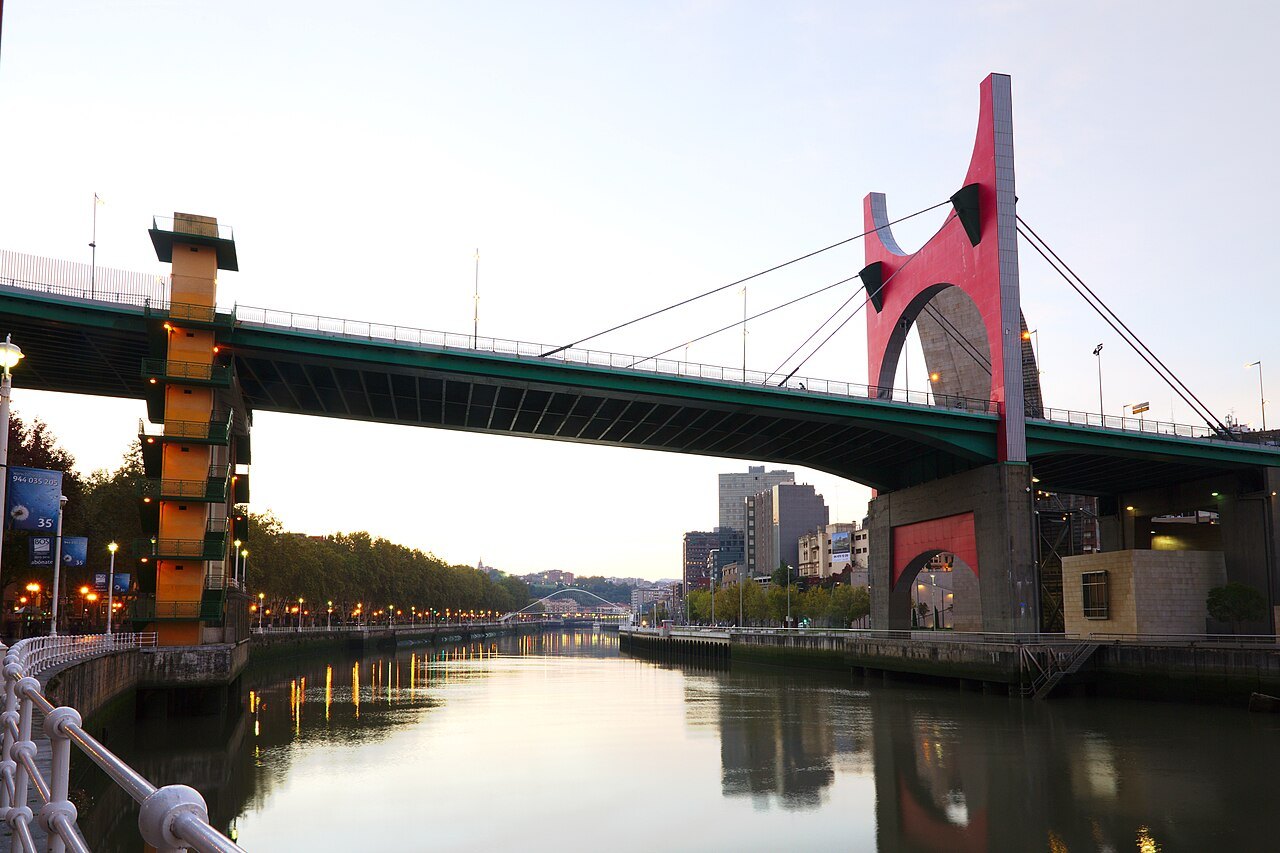 La Salve bridge from the riverbank, its red arch and the yellow stair tower beside it