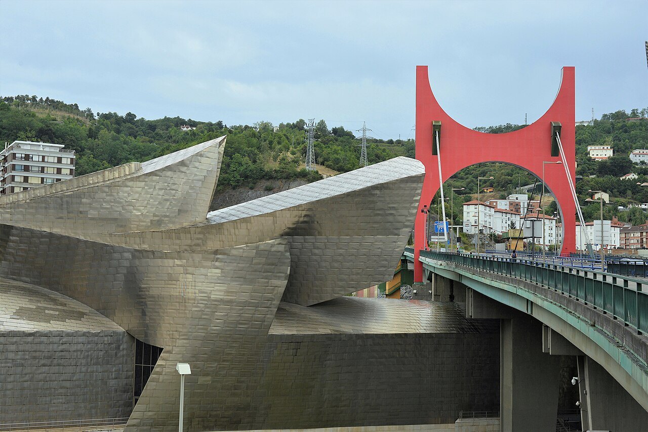 The Guggenheim curving beneath La Salve bridge and its red arch