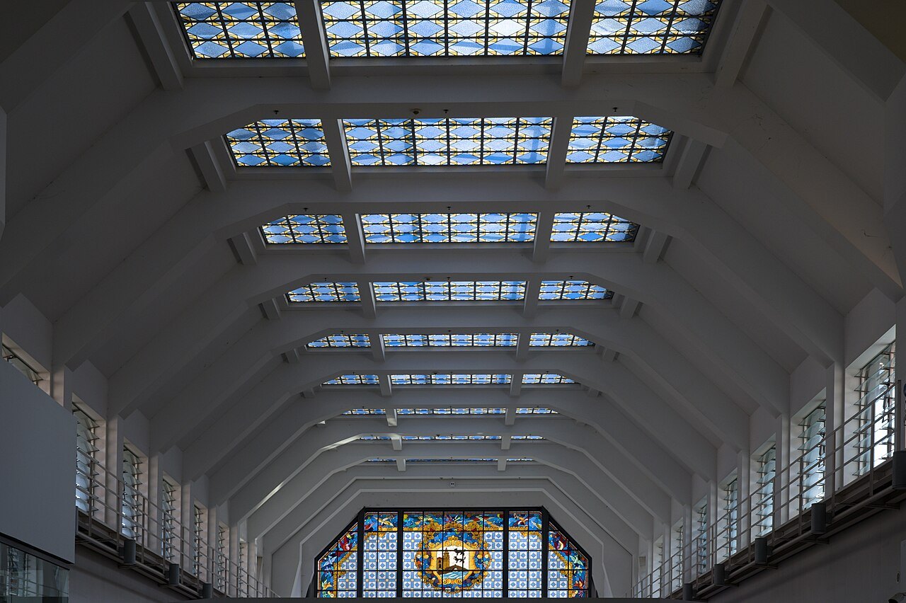 The white vaulted roof of the Ribera market, skylights leading to the stained-glass window