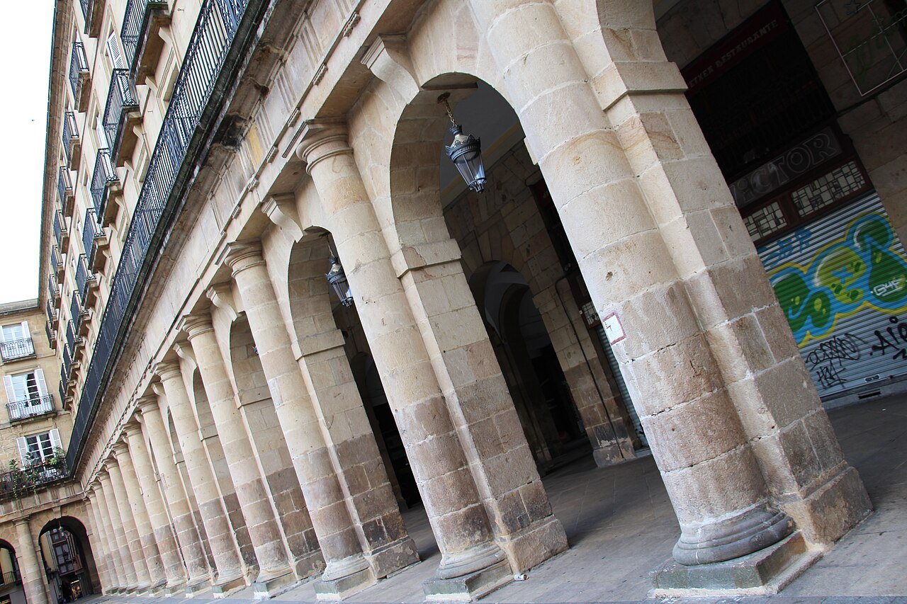 Stone columns and round arches of the Plaza Nueva's arcades