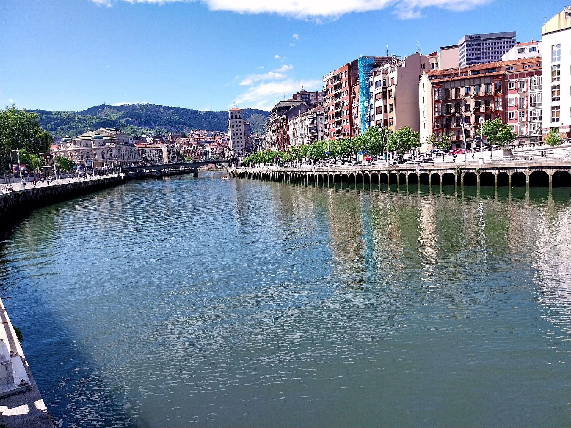 The Ría between its quays in the center of Bilbao, the hills beyond
