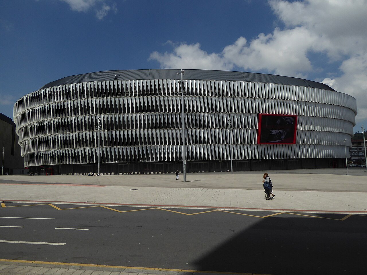 The long curve of San Mamés from the street, under a big sky
