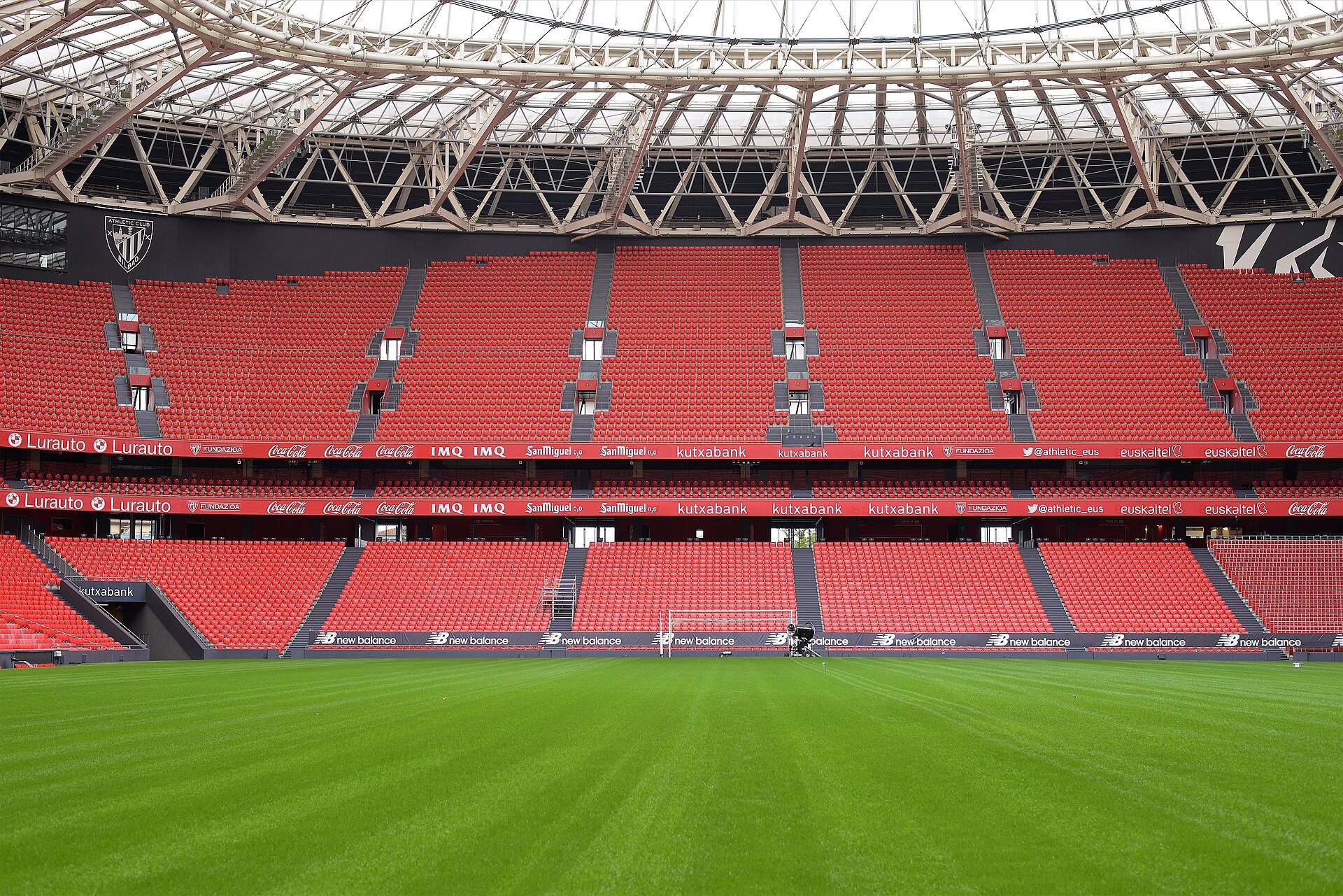 The red seats of San Mamés rising around an empty pitch