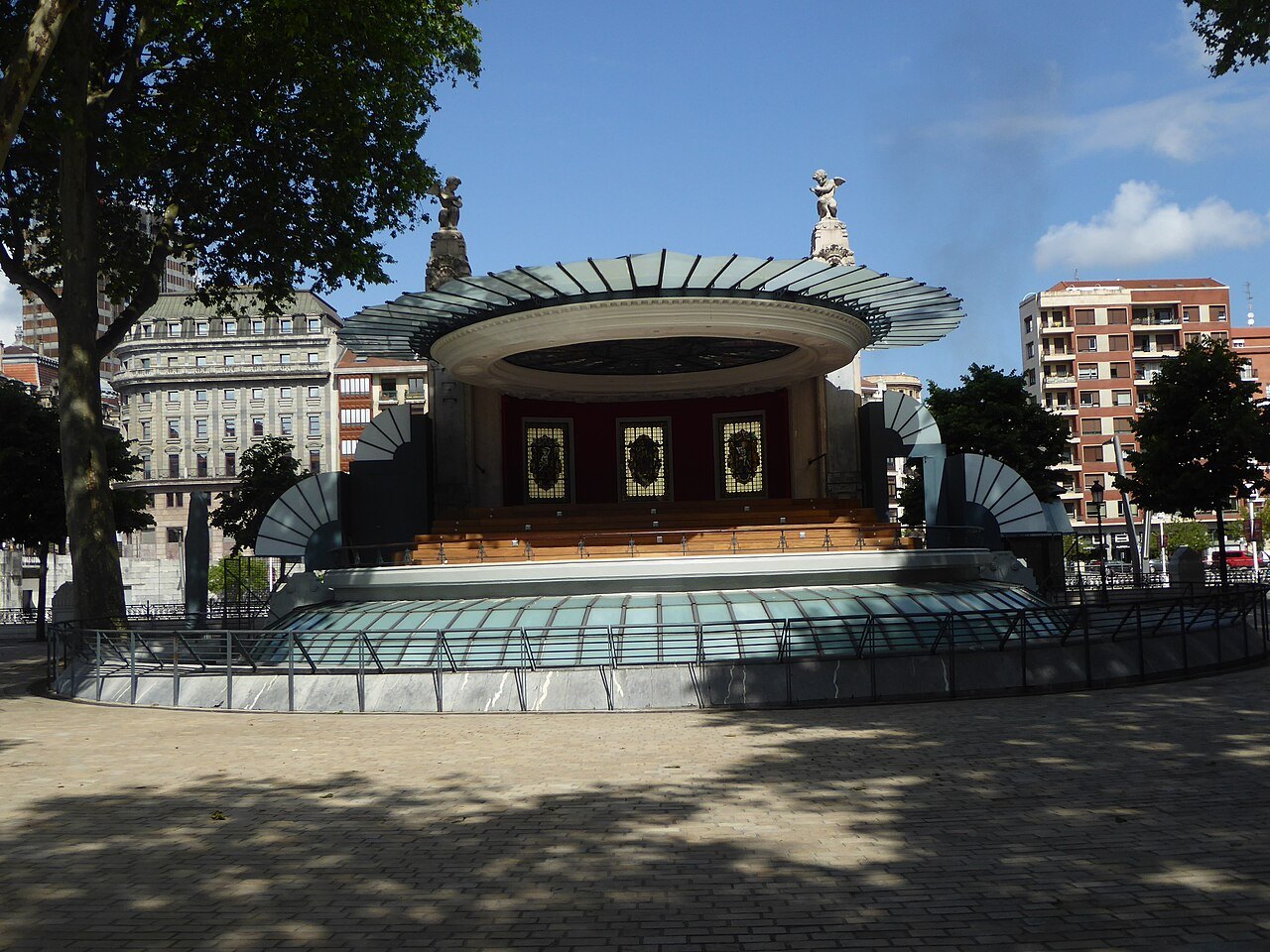 The bandstand of the Arenal under the trees, the river behind