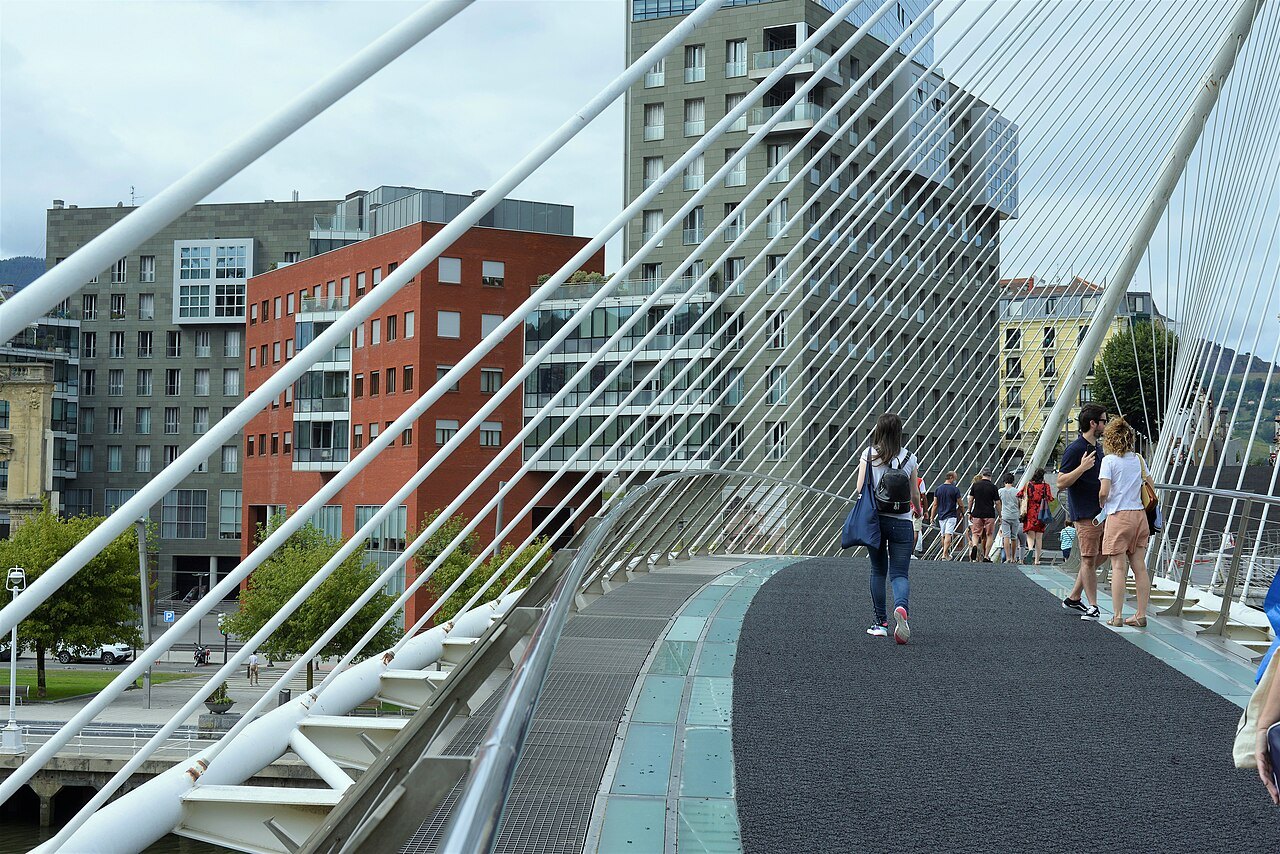 Walkers on the glass deck of Zubizuri, the Isozaki towers behind